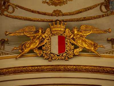 Spostando lo sguardo verso l�arcoscenico notiamo due angeli in tiglio e cartapesta dorati che reggono lo stemma comunale...
